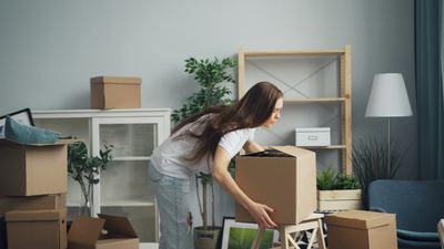 A woman packing a box while downsizing